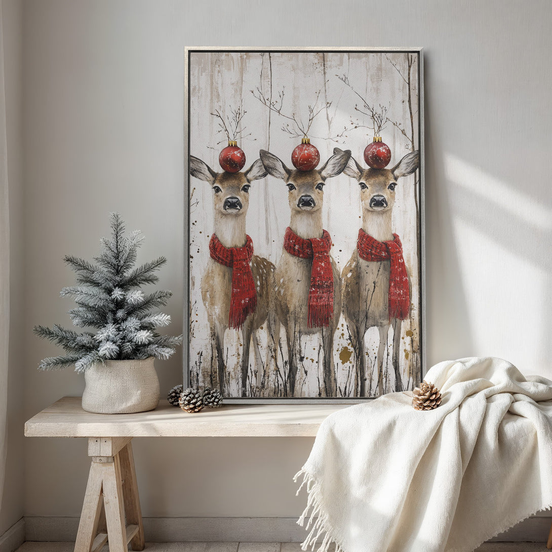 Framed Wall Art featuring three deer with red scarves and ornaments. Rustic style, neutral and red color palette, perfect for Christmas decor.