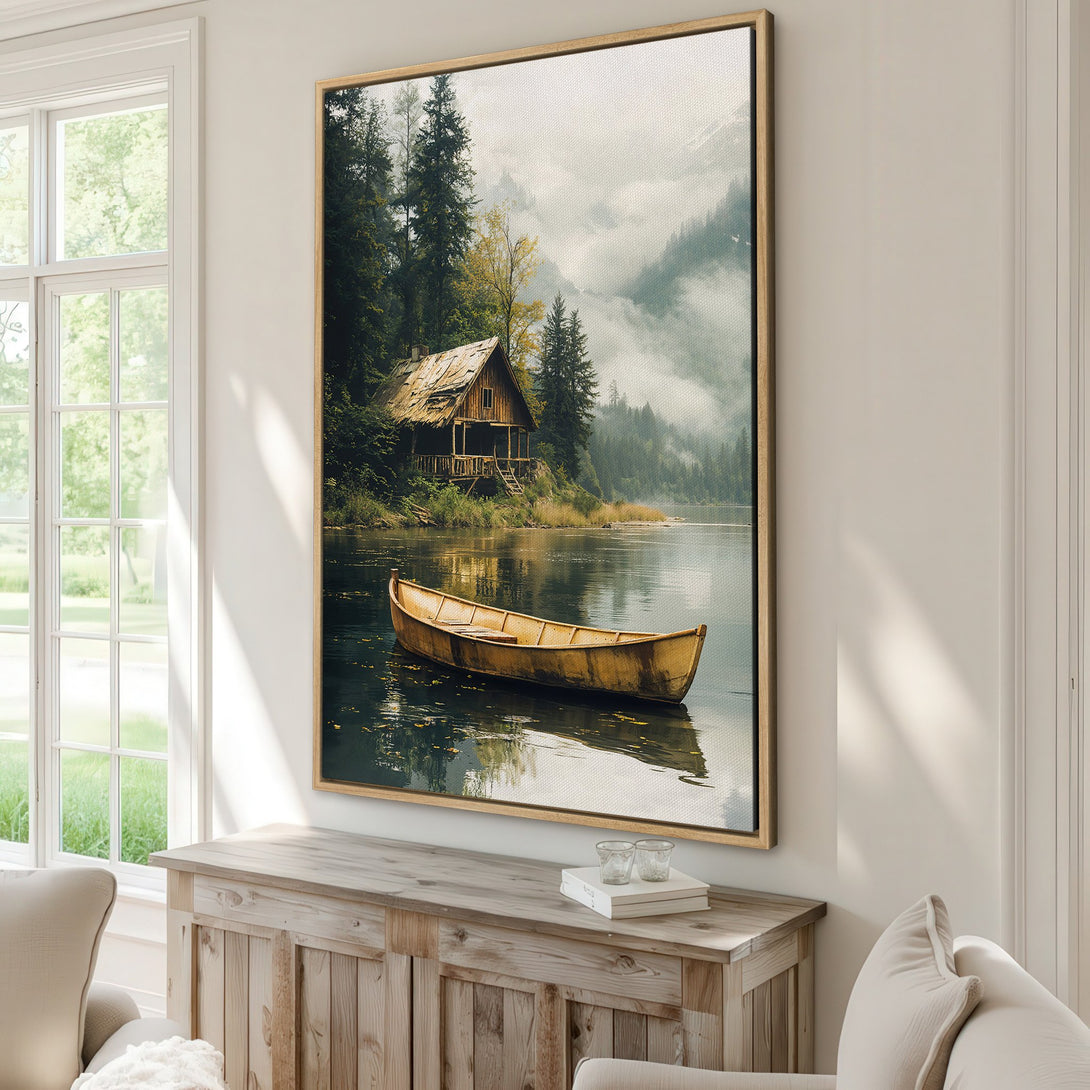 Framed Wall Art: Serene lake scene Canvas Print with cabin & boat, featuring a muted green and gold color palette, perfect for adding a touch of nature to your home.