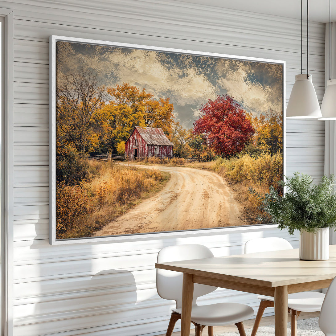 Framed Wall Art of a rustic barn on a dirt road, autumn landscape in warm yellow, red, and brown tones. Perfect for adding cozy charm.