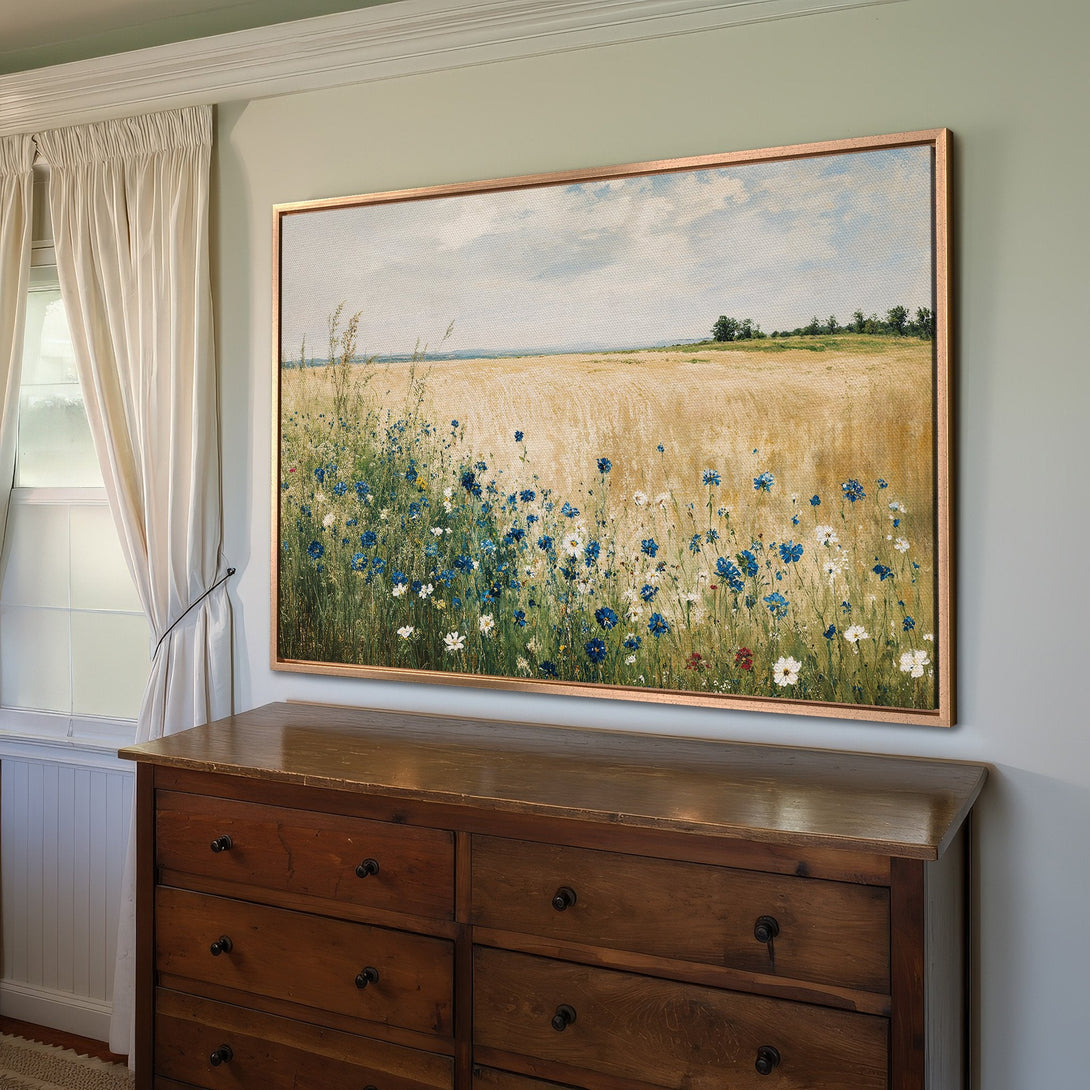 Framed Wall Art: Impressionist field scene with blue wildflowers. Warm, earthy tones create a serene feel. Perfect for adding a touch of nature to your home.