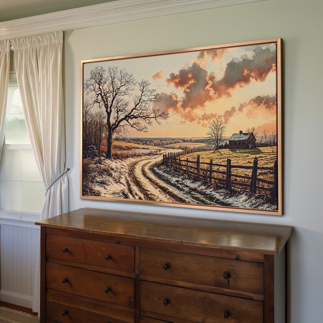Framed Wall Art: Winter landscape Canvas Print with warm sunset hues. Rustic style featuring a snowy road and cabin, perfect for cozy interiors.