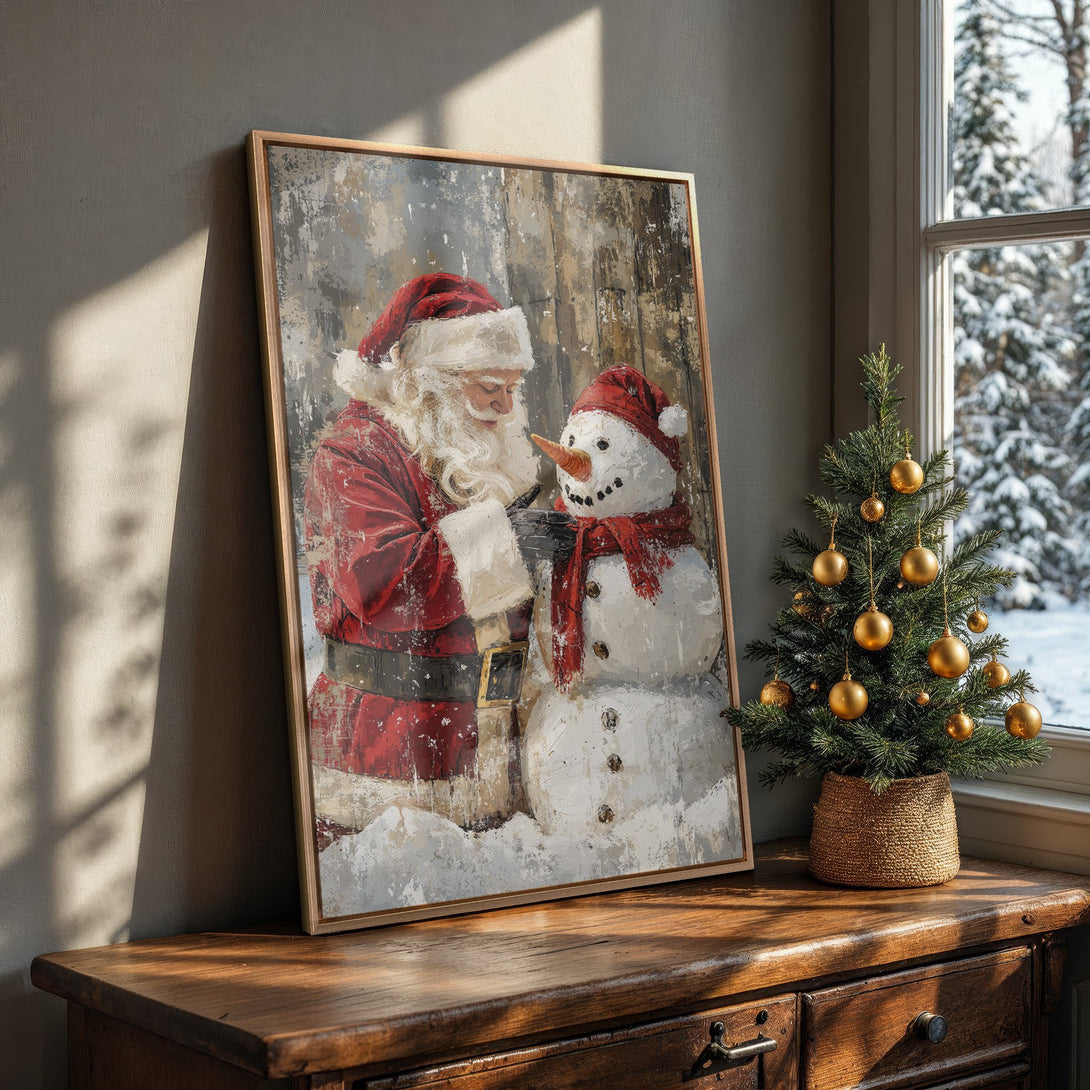 Framed Wall Art: Santa Claus painting a snowman. Rustic style, red & white color palette, perfect Christmas decor for your home.