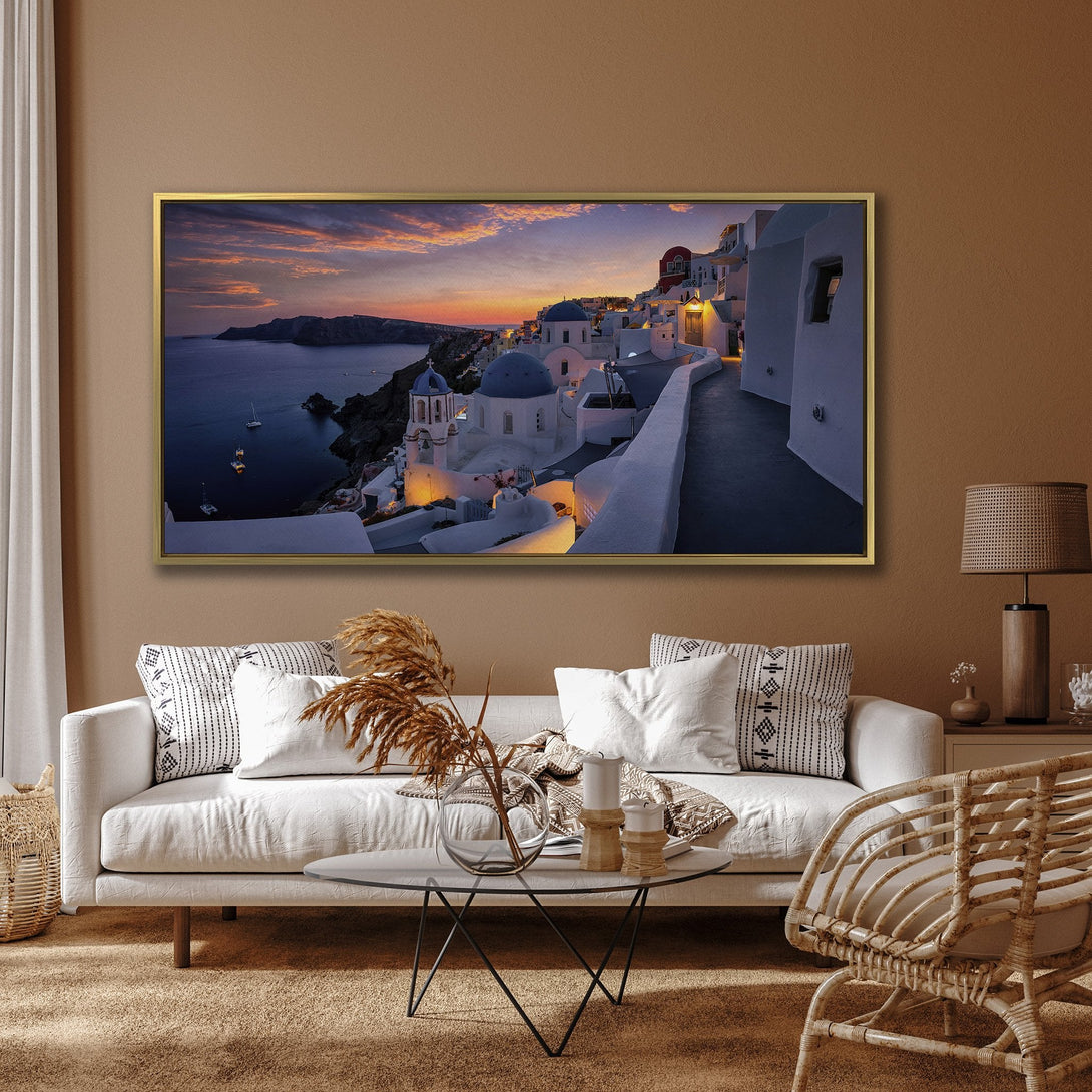 Canvas Print of Santorini sunset scene with white buildings, blue domes, and warm orange sky. Coastal art in a modern interior.
