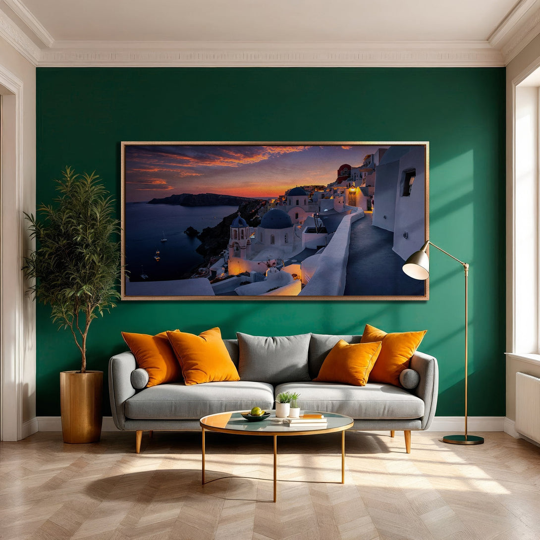 Framed Wall Art of Santorini sunset. Coastal landscape Canvas Print in warm tones, displayed in a modern living room with green wall and orange accents.
