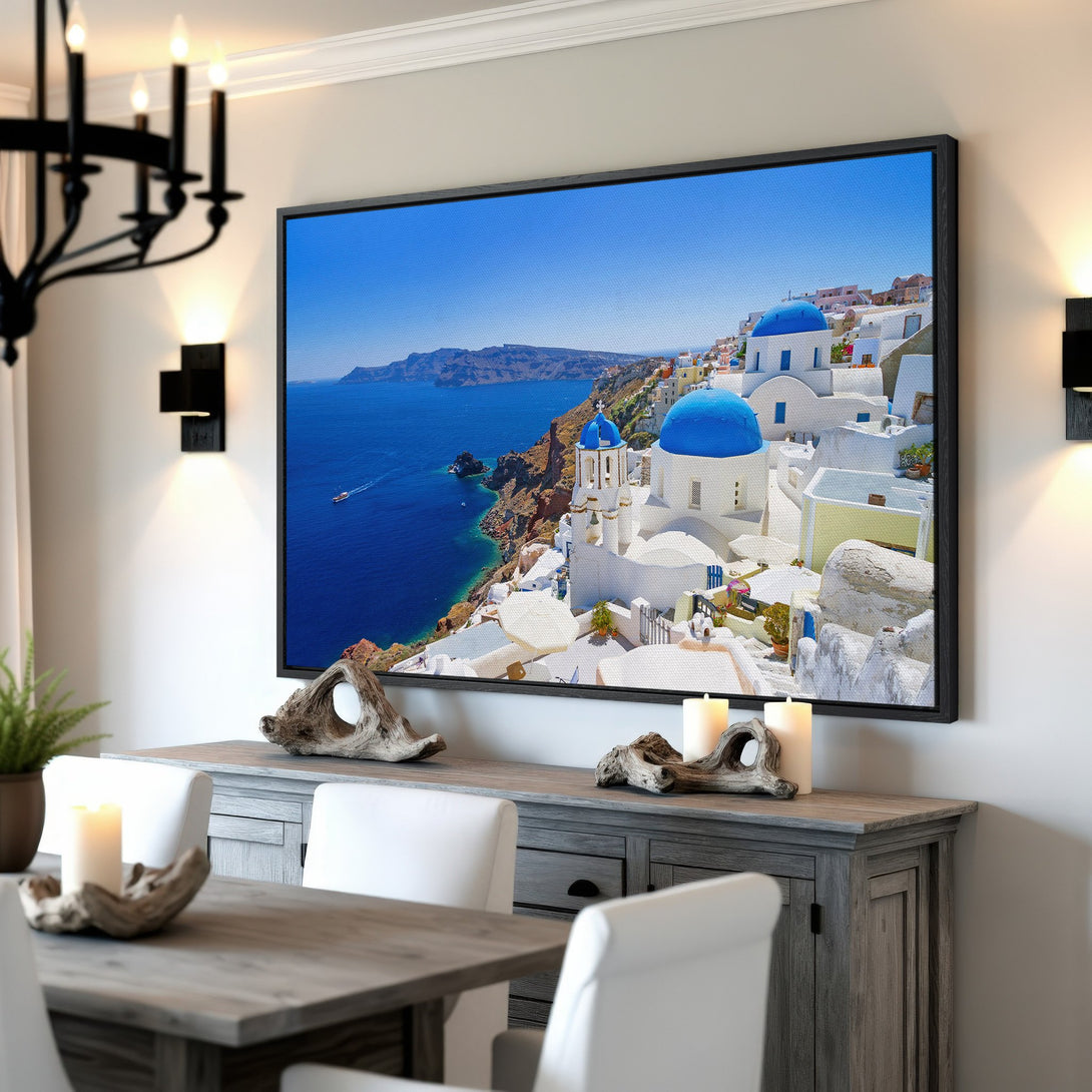 Framed Wall Art: Santorini landscape Canvas Print in a modern interior. Features blue, white, and neutral tones, evoking a Mediterranean aesthetic. Perfect for home decor.