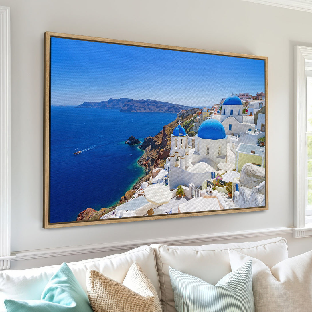Framed Wall Art: Santorini Canvas Print. Captivating coastal scene with blue domes, white buildings, and azure sea. A vibrant, Mediterranean color palette for your home decor.