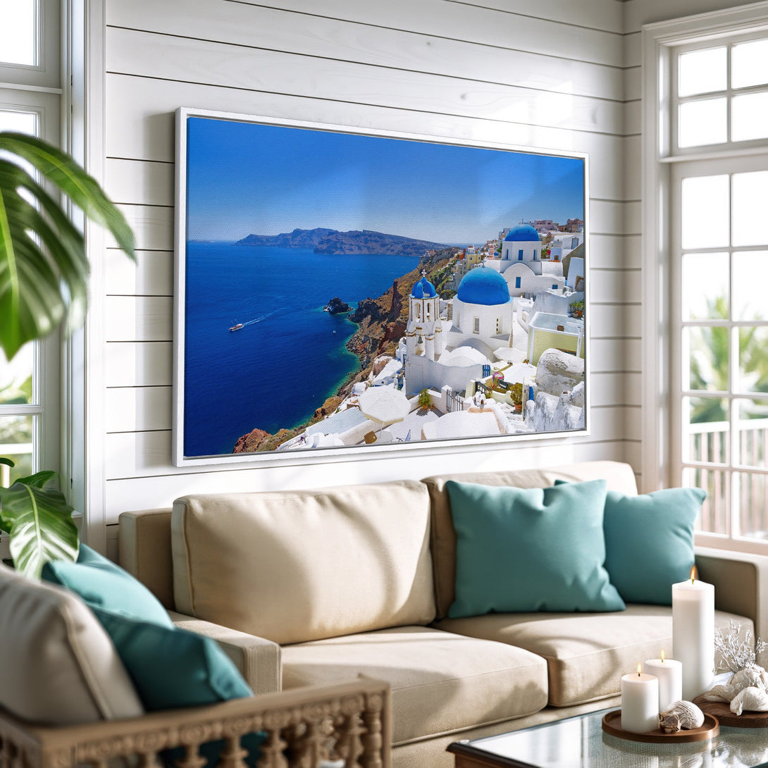 Framed Wall Art of Santorini, Greece. Coastal style canvas print with blue, white, and sea-toned color palette. Perfect for adding a touch of wanderlust to your home.