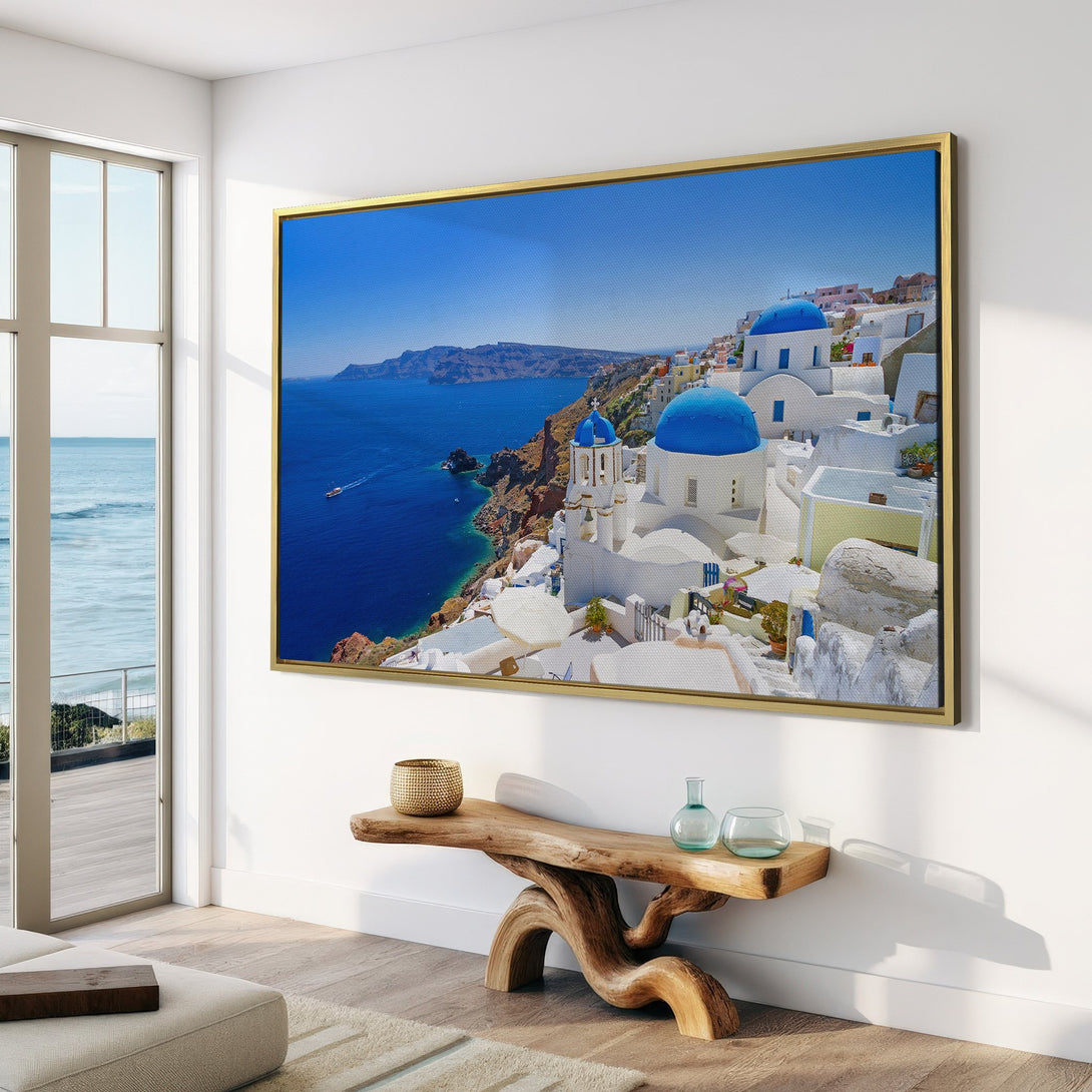 Canvas Print of Santorini landscape with blue domes and sea, displayed in a modern interior. Features a vibrant blue and white color palette.