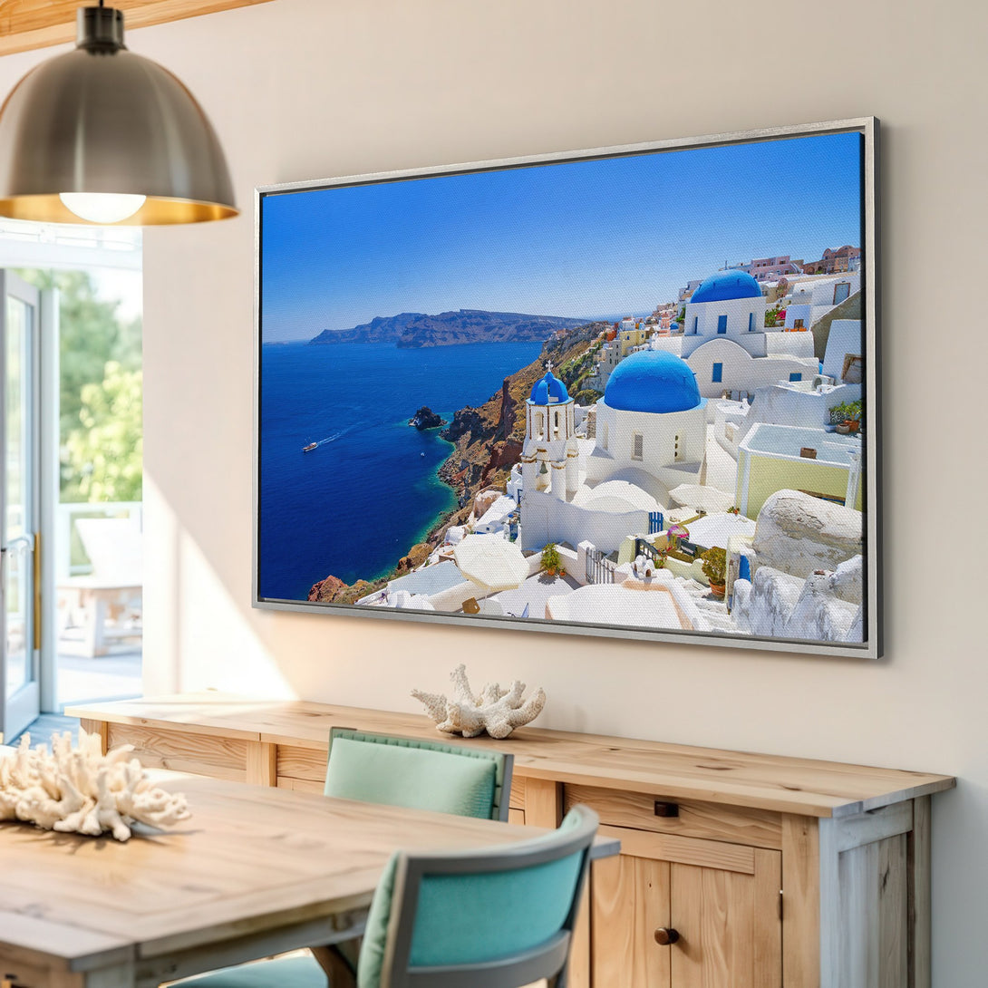 Framed Wall Art of Santorini, Greece. Stunning blue and white architecture against a vibrant blue sea. Add a touch of Mediterranean charm to your home!