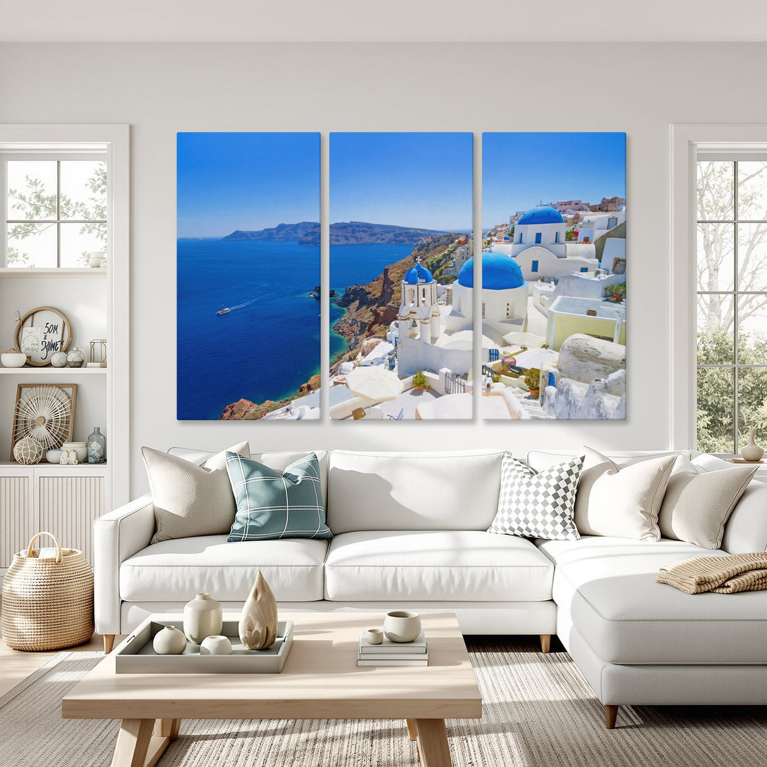 Canvas Print of Santorini, Greece featuring blue domes and white buildings, displayed in a modern living room with a vibrant blue and white color palette.