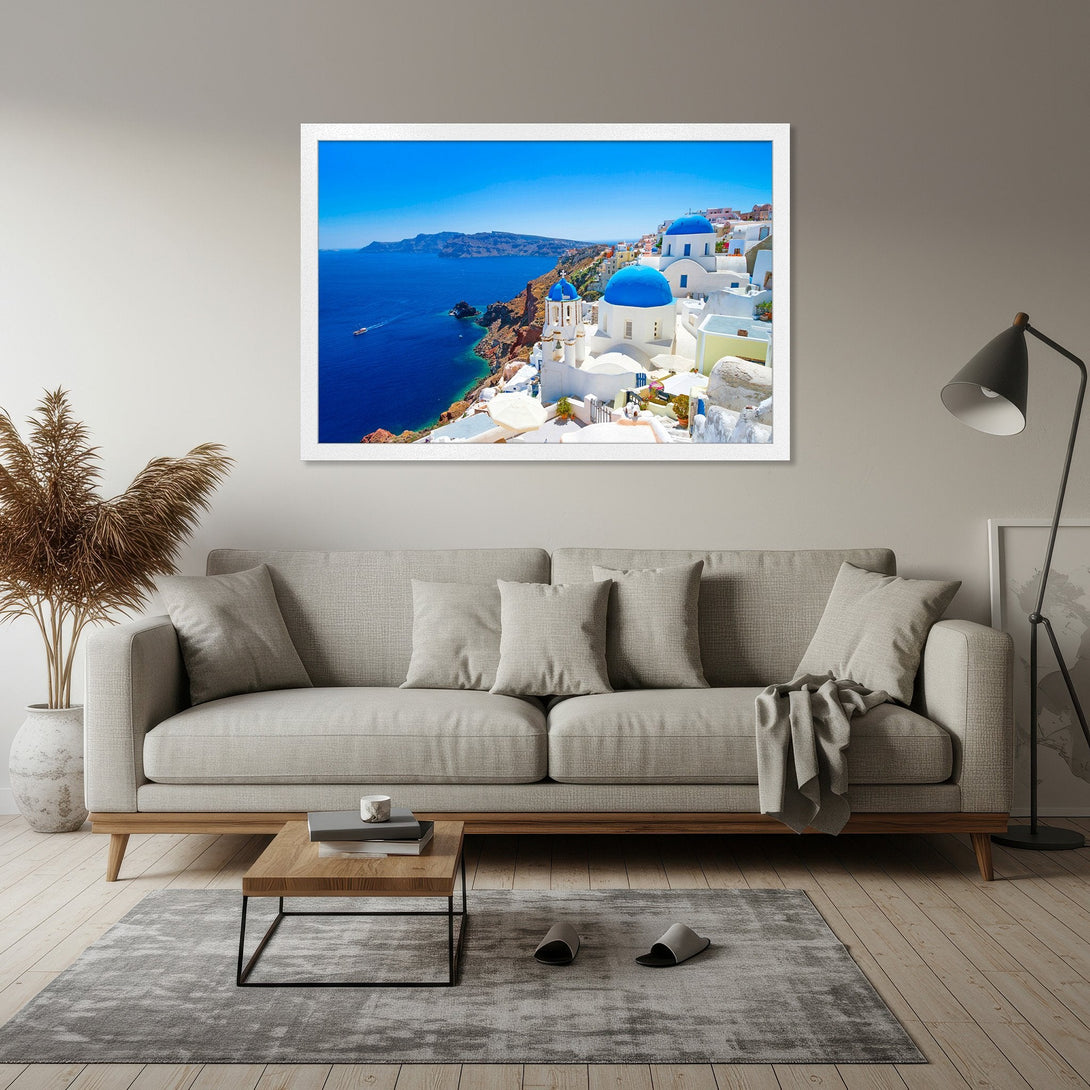 Framed Poster of Santorini, Greece. Coastal landscape art with blue domes, white buildings, and vibrant blue sea. Perfect wall decor.