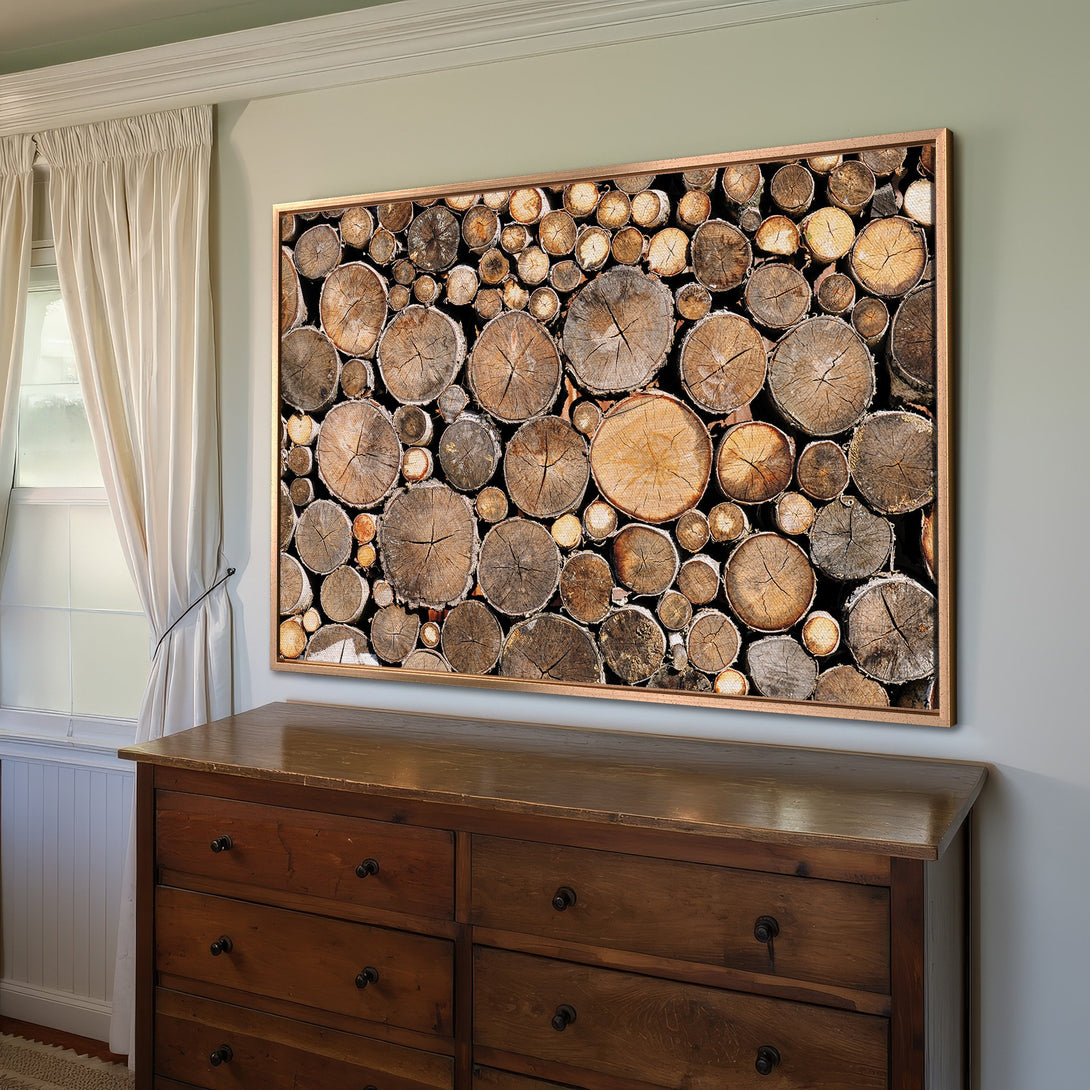 Framed Wall Art featuring a wood log pile. Rustic style with warm brown and neutral tones. Perfect for adding natural decor to your home.