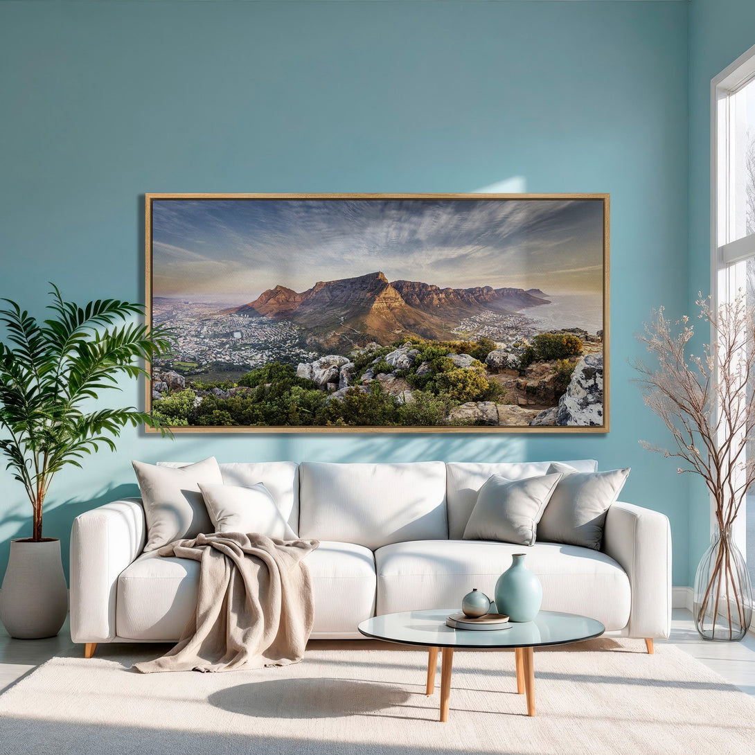 Framed Wall Art of a mountain landscape in warm tones, displayed in a modern living room with a teal wall. Enhance your home decor with this stunning Canvas Print!