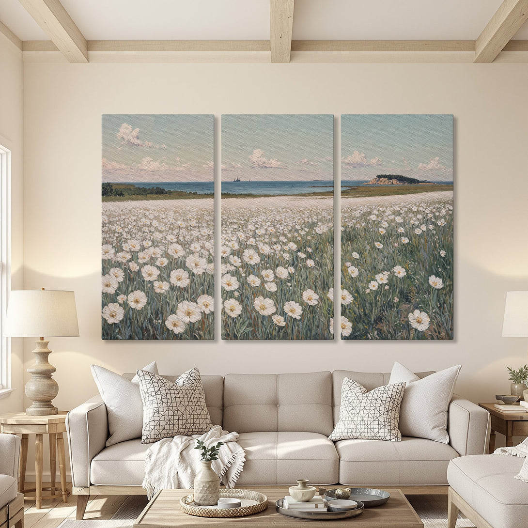 Canvas Print triptych of a serene field of white flowers with a coastal background, in a soft, muted color palette. Perfect for living room decor.