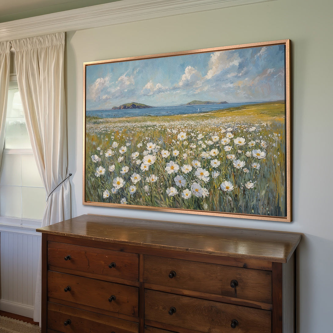Framed Wall Art: Coastal landscape Canvas Print with white flowers, blue sky, and gold frame. Perfect for adding a touch of serenity to your home!