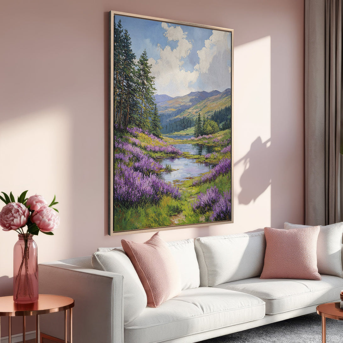 Framed Wall Art: Serene landscape Canvas Print with a river, purple flowers, and mountains. Soft, warm color palette in a cozy interior setting.