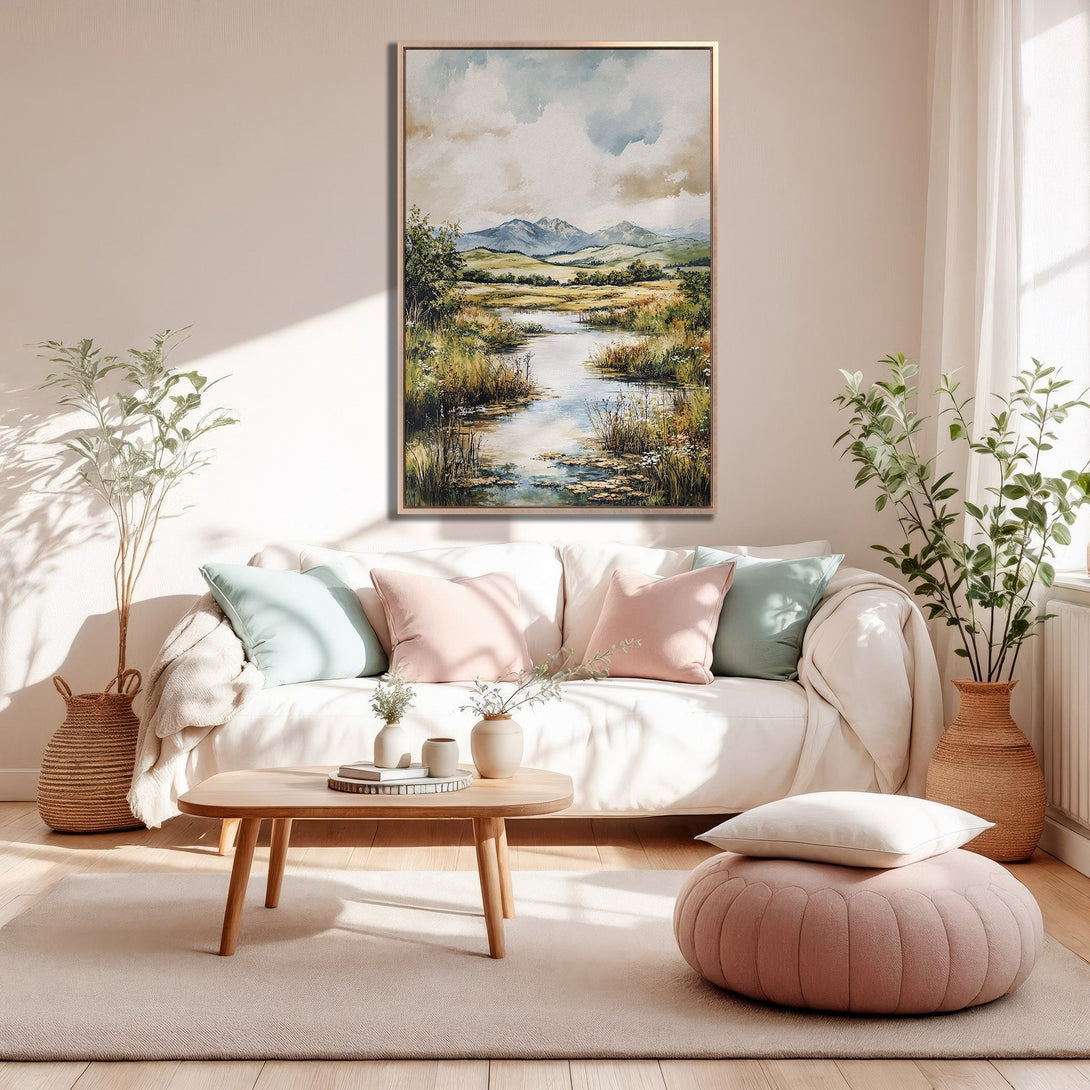 Framed Wall Art: Serene landscape painting in a neutral living room. Soft watercolor style, featuring a river scene with muted blues, greens, and beige tones.
