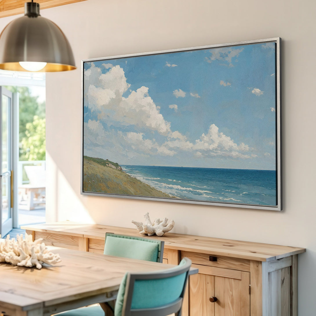 Framed Wall Art Canvas Print of a serene beach scene with blue sky and white clouds. Coastal style art with a calming blue and neutral color palette.