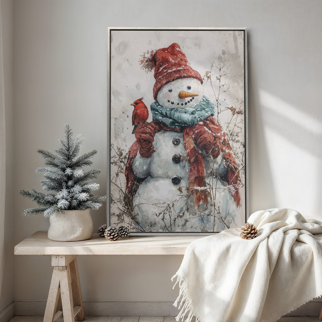 Framed Wall Art featuring a watercolor snowman with a cardinal. Cozy winter decor in red, blue, and neutral tones. Perfect for holiday or seasonal decorating.