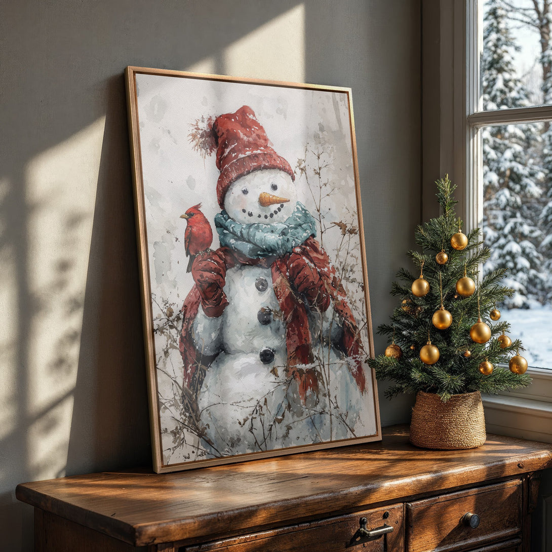 Framed Wall Art featuring a watercolor snowman with a cardinal. Warm, inviting color palette of reds, blues, and whites. Perfect winter decor!