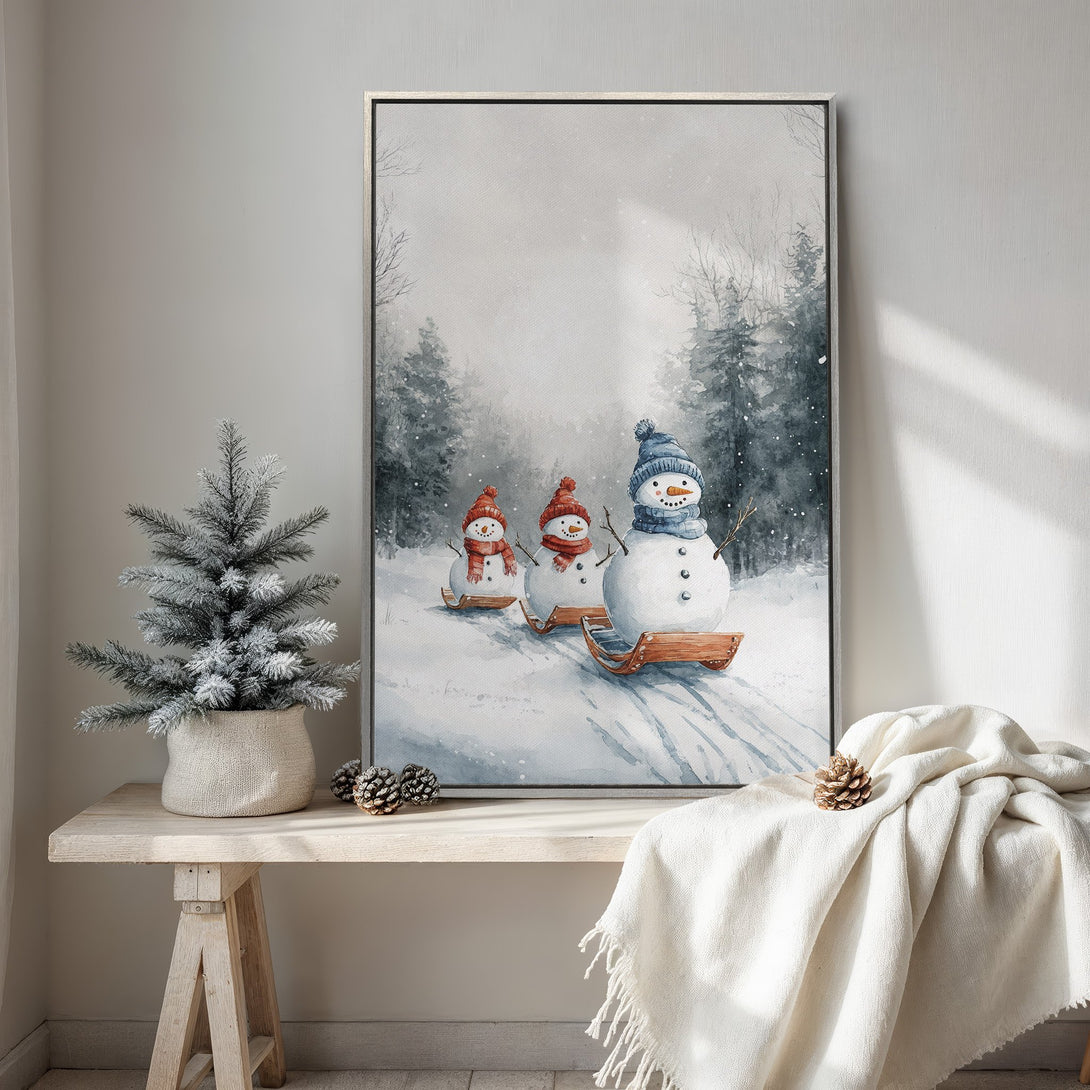 Framed Wall Art featuring a watercolor winter scene with snowmen, in a cool blue and gray palette. Perfect for cozy winter decor.