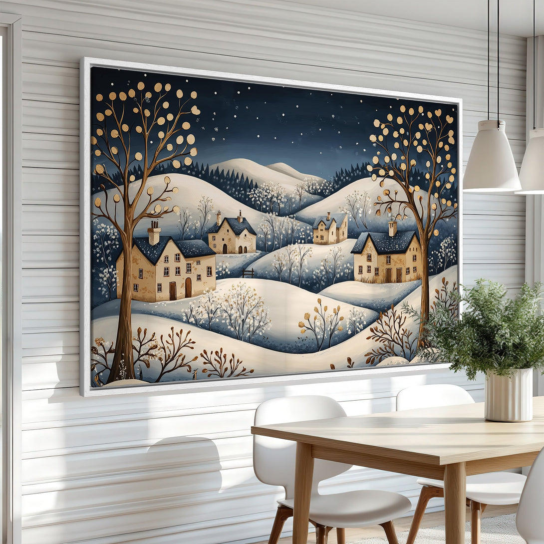 Framed Wall Art: Winter landscape canvas print with charming houses, trees, and snowy hills in a serene blue, beige, and gold color palette. Perfect for cozy decor!