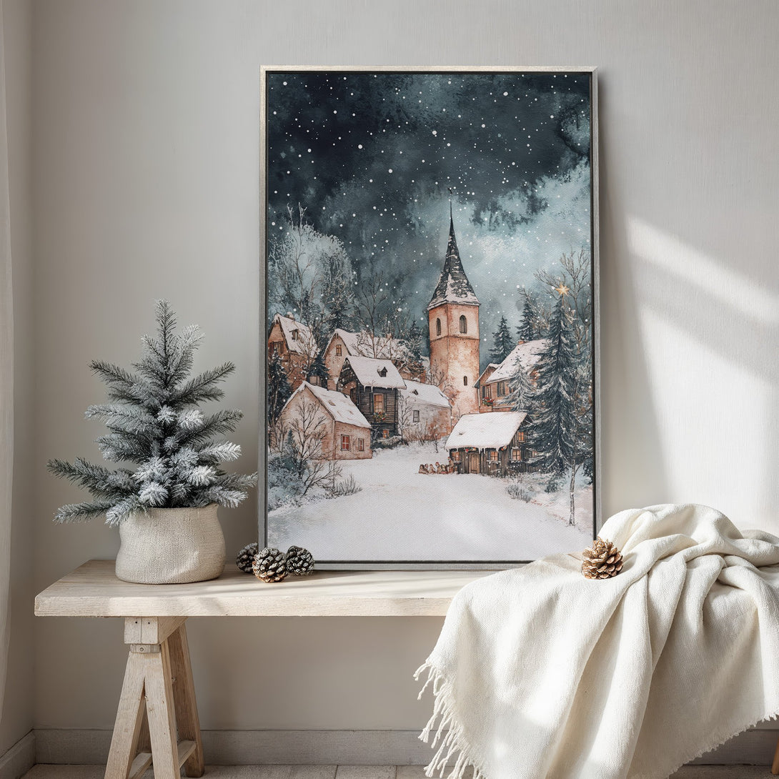 Framed Wall Art featuring a watercolor winter village scene. Soft blues, grays, and warm neutrals create a cozy, inviting atmosphere. Perfect for holiday decor!