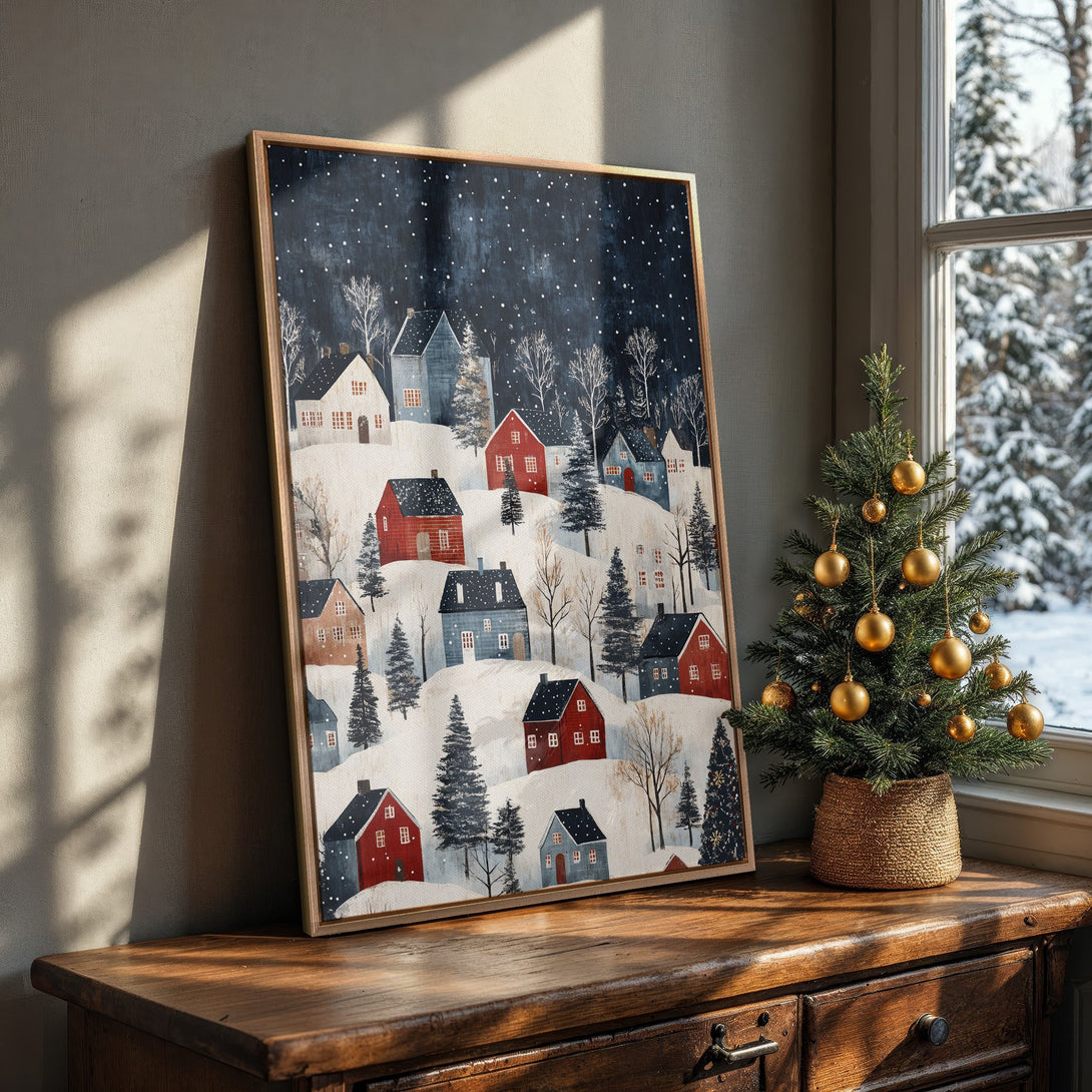 Framed Wall Art: Winter village scene with red and blue houses on a snowy landscape. Cozy, folk art style with a dark blue and white color palette. Perfect for holiday decor!