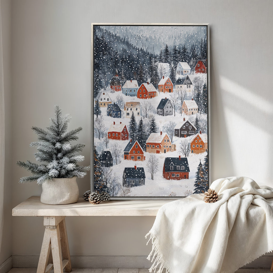 Framed Wall Art: Winter village scene in a cozy, whimsical style. Features colorful houses in a snowy landscape with a cool, muted color palette. Perfect for holiday decor.