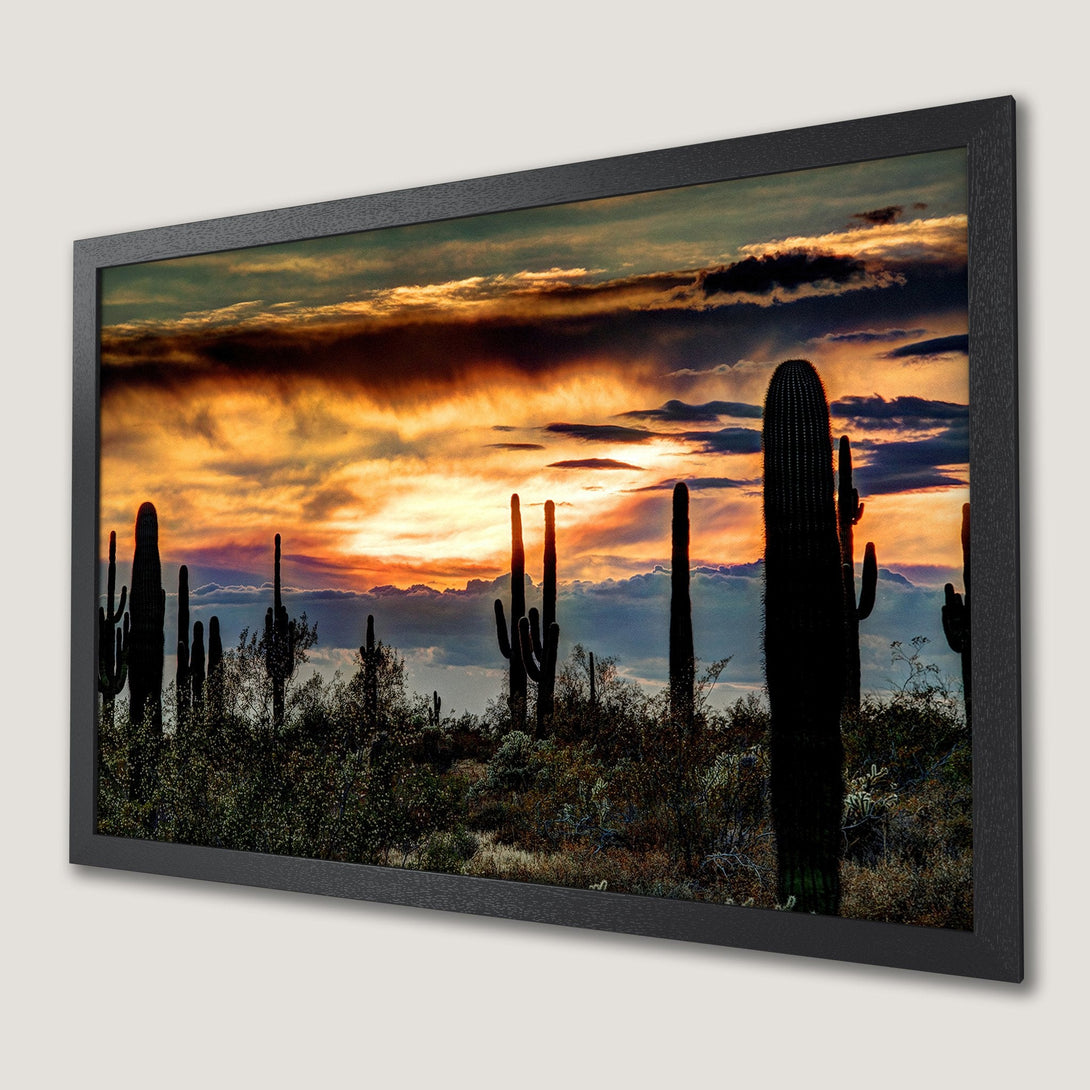 Framed Poster featuring a desert sunset with cacti silhouettes. Warm orange and gold tones with a dramatic, artistic style.