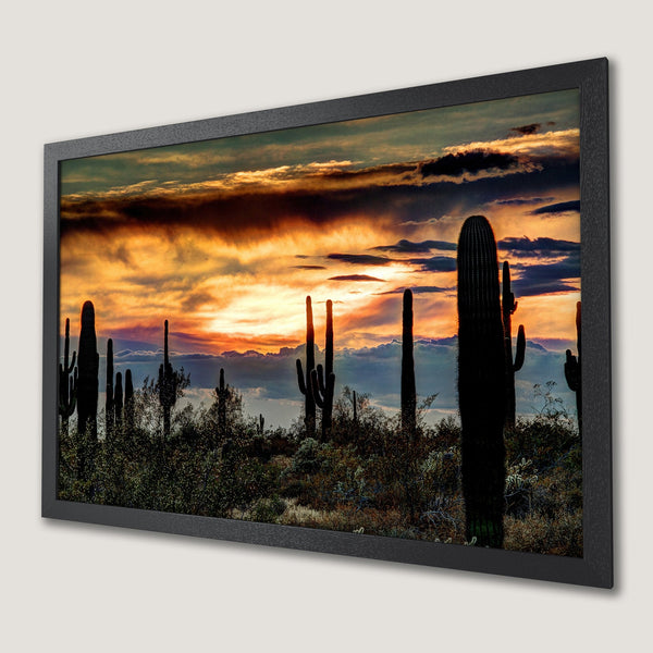 Framed Poster featuring a desert sunset with cacti silhouettes. Warm orange and gold tones with a dramatic, artistic style.