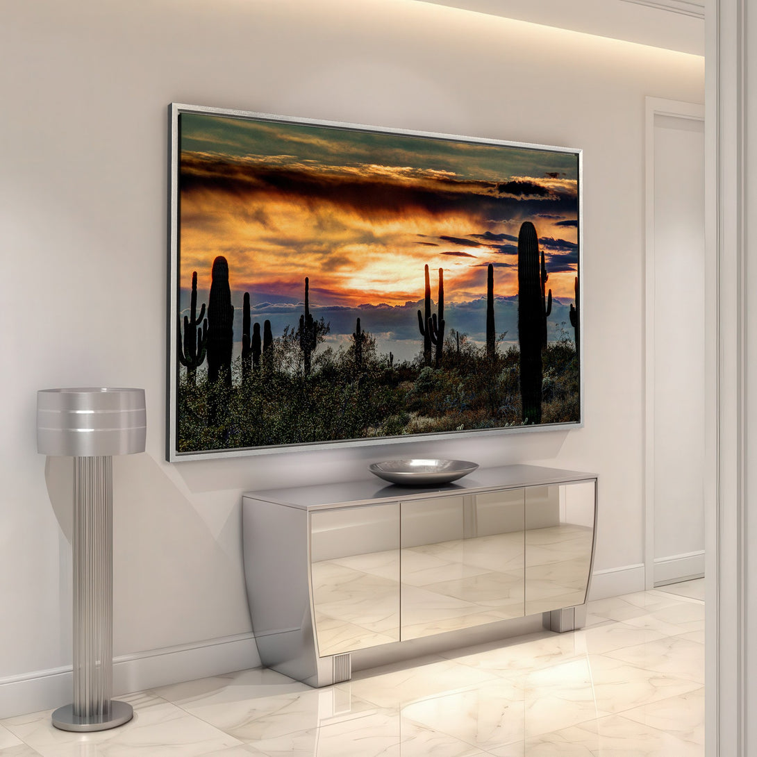 Framed Wall Art featuring a desert sunset with silhouetted cacti. Warm orange and yellow hues create a dramatic sky. Perfect for adding a touch of nature to your home.