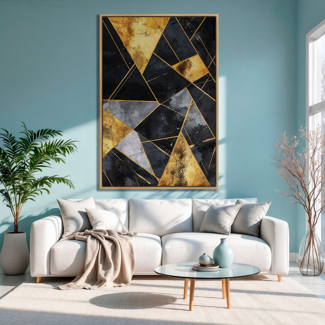 Framed Wall Art featuring an abstract geometric design in gold, black, and gray tones, displayed in a modern living room with a blue wall.