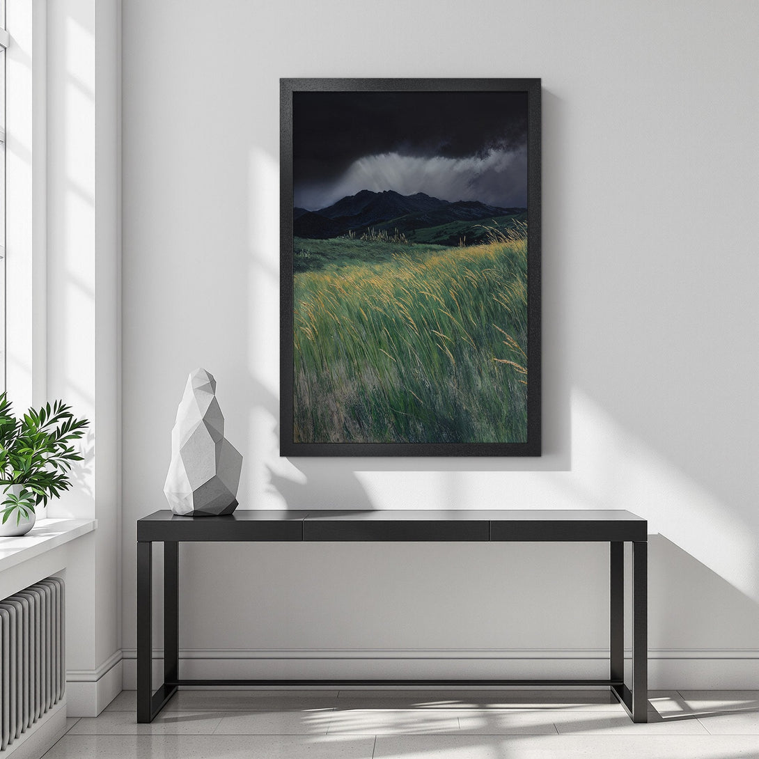 Framed Poster of a dramatic landscape with mountains, grass and dark sky. Earth tones and moody style. Perfect wall art.