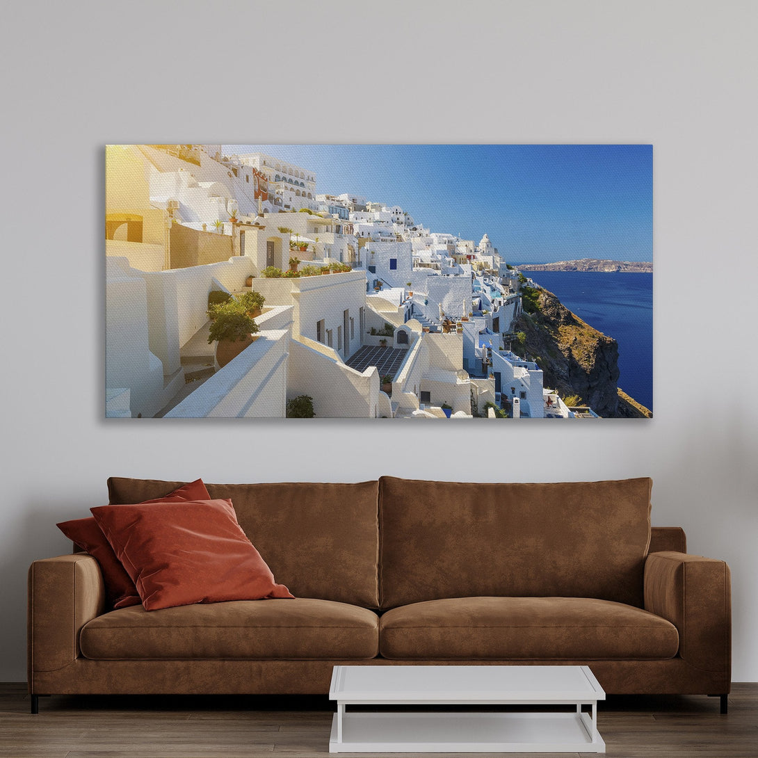 Framed Wall Art of Santorini village. Capture the beauty of Greece with this stunning Canvas Print. Coastal style with white buildings & blue sea.