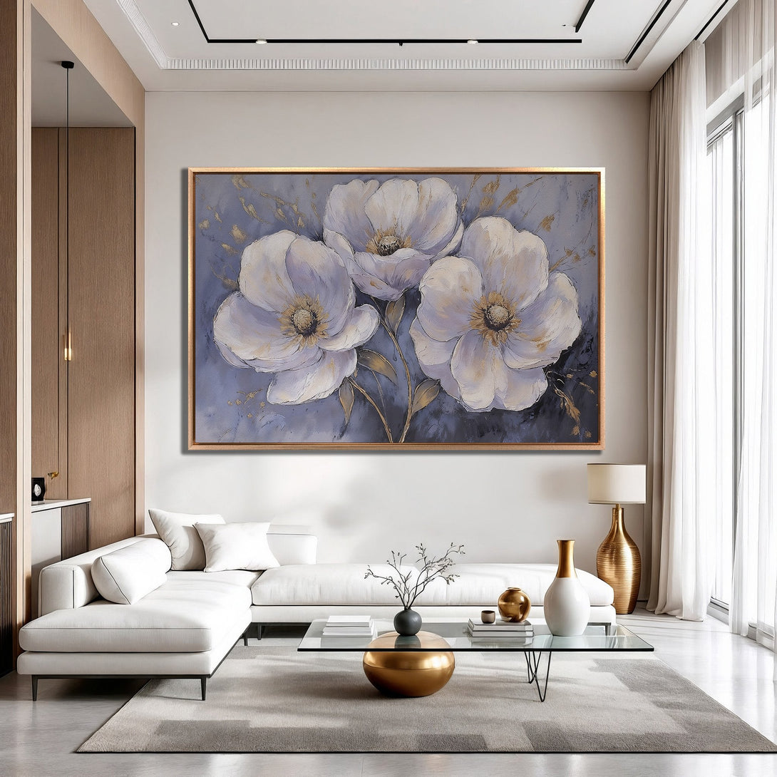 Framed Wall Art: Elegant floral painting in a modern interior. Features large white flowers with gold accents on a muted blue background. Adds sophistication.