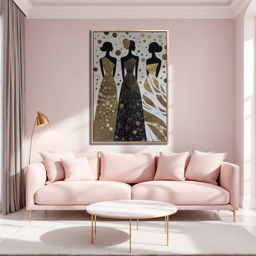 Framed Wall Art featuring elegant women in gold and black dresses, displayed in a blush pink living room. Modern art with a glamorous, sophisticated style and gold accents.