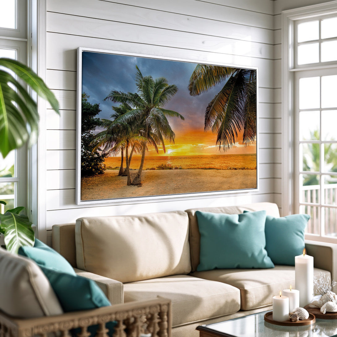 Framed Wall Art: Tropical beach sunset canvas print in a coastal living room. Features palm trees, warm sunset hues, and a serene, relaxing vibe.