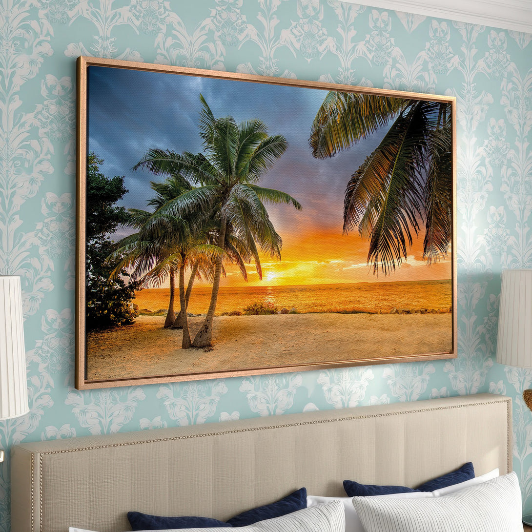 Framed Wall Art: Tropical beach scene with palm trees at sunset. Warm orange and yellow hues create a vibrant, relaxing atmosphere. Perfect for home decor.