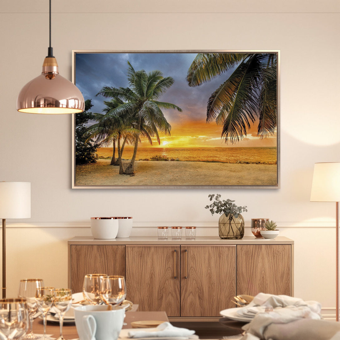 Framed Wall Art: Tropical beach sunset canvas print. Coastal decor with palm trees, warm orange & blue hues, perfect for a serene living space.