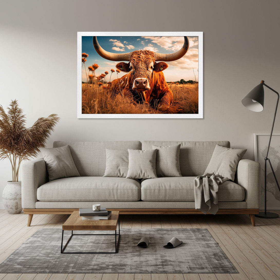 Framed Poster featuring a majestic bull in a field. Rustic style with warm, earthy tones and a touch of blue sky. Perfect wall art!