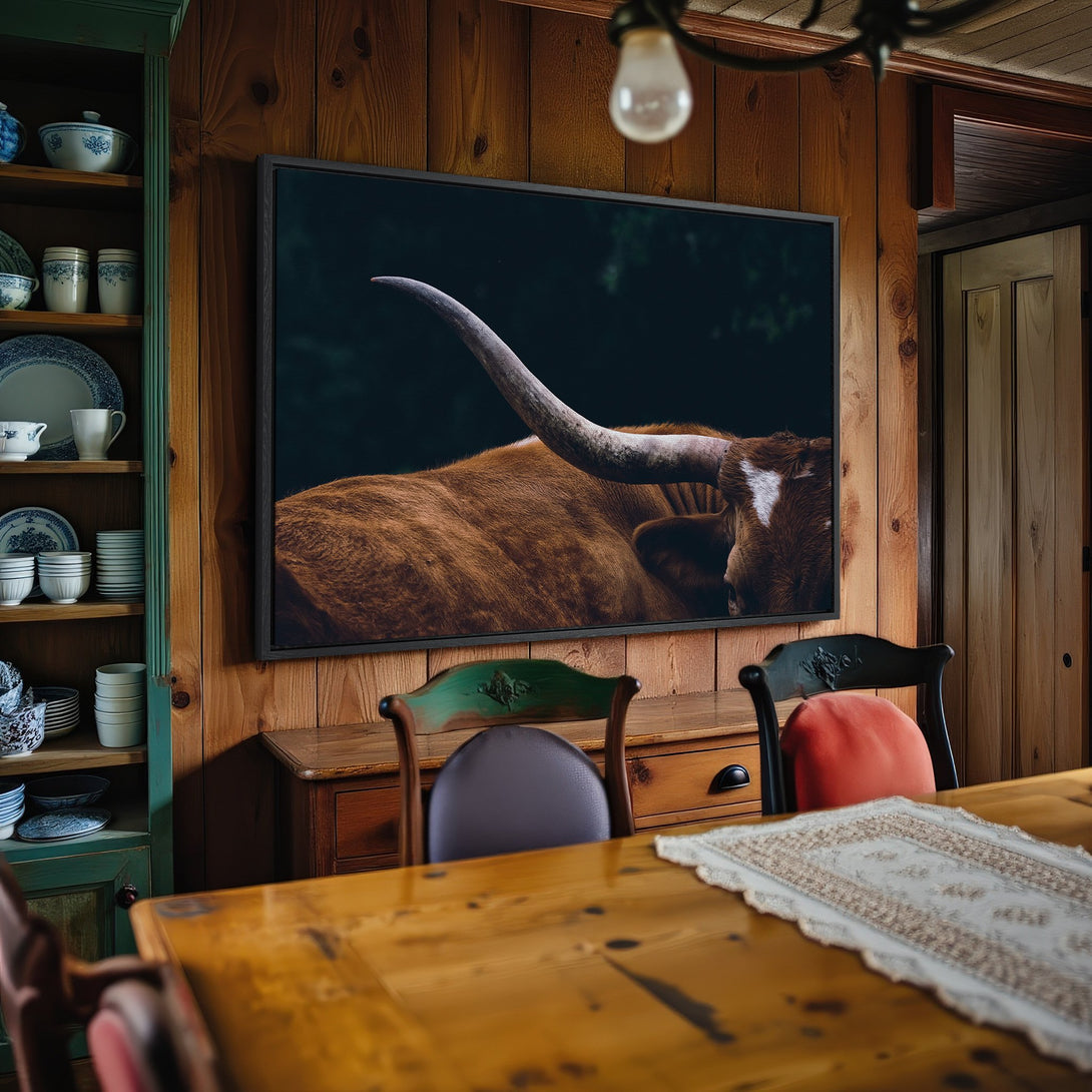 Framed Wall Art: Rustic canvas print of a longhorn bull in a warm, inviting interior. Earthy tones create a cozy, farmhouse vibe.