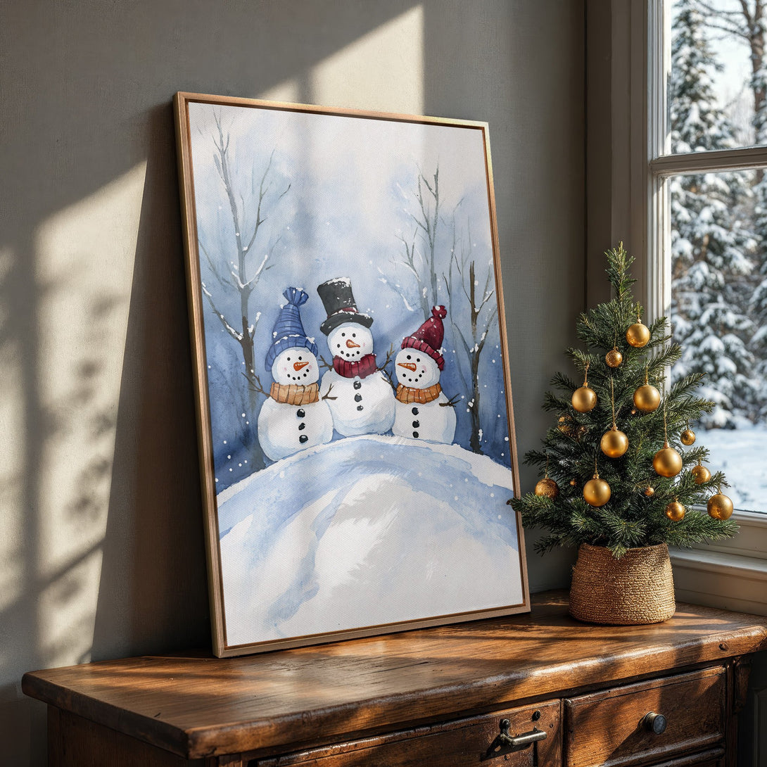 Framed Wall Art featuring a watercolor painting of snowmen in a winter scene. Blue and white color palette, perfect for holiday decor.