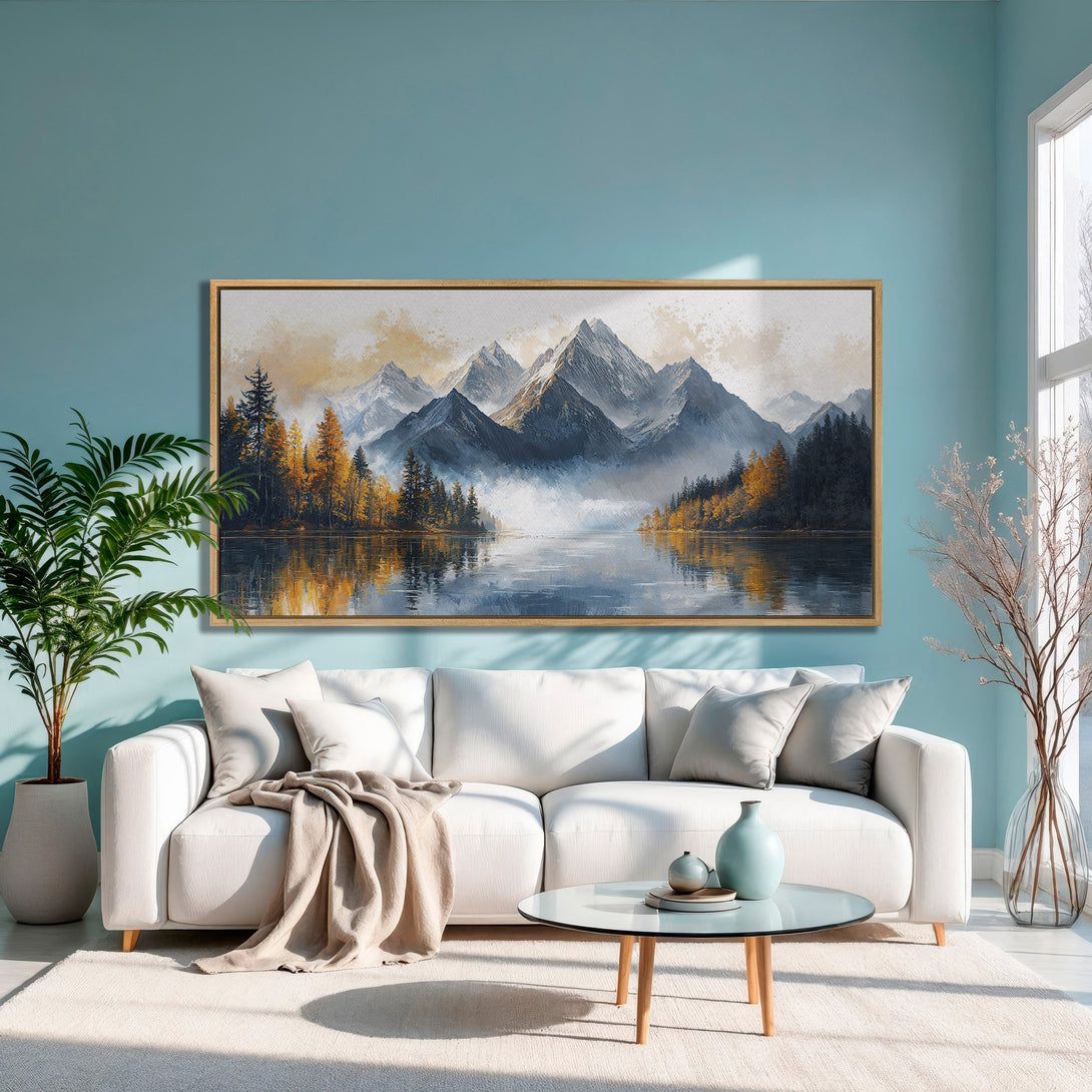 Framed Wall Art: Mountain landscape canvas print in a modern living room. Featuring a serene lake scene with a blue, gold, and gray color palette.