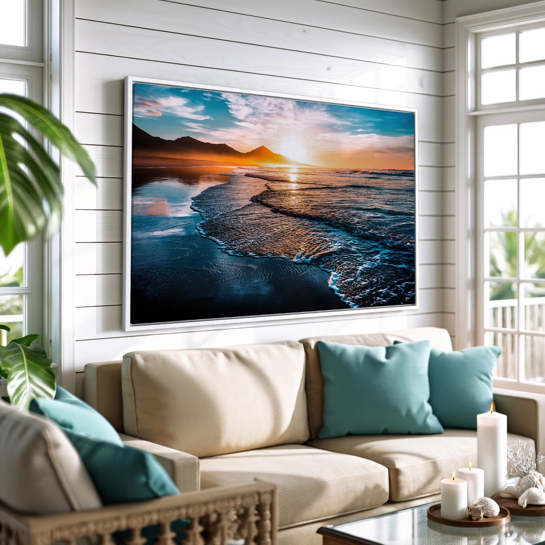 Framed Wall Art: Beach sunset canvas print in a coastal living room. Featuring vibrant blues, oranges, and a touch of teal. Perfect for home decor.