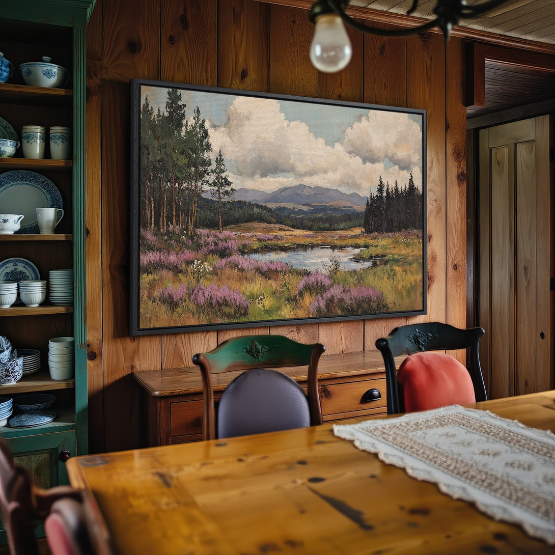 Framed Wall Art: Landscape Canvas Print in a rustic dining room. Features a serene nature scene with purple wildflowers and a calming blue and green color palette.