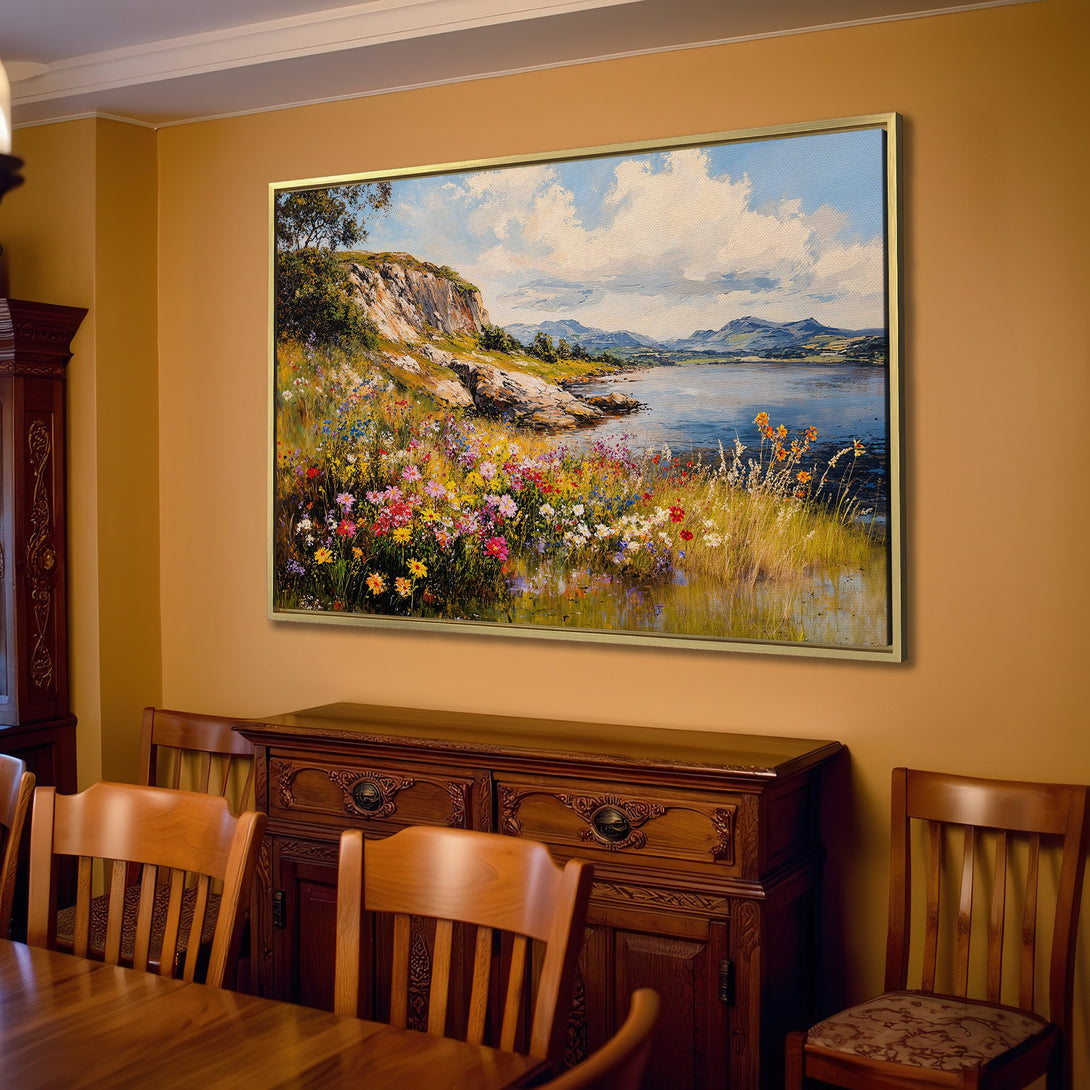 Canvas Print of a vibrant landscape painting with flowers, mountains, and water. Warm color palette, displayed in a cozy living room setting.