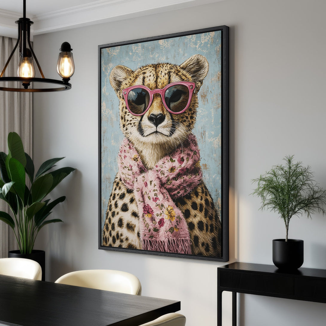 Framed Wall Art: Stylish cheetah portrait with pink sunglasses and scarf, set against a blue backdrop. Modern decor with a pop of color for your home.