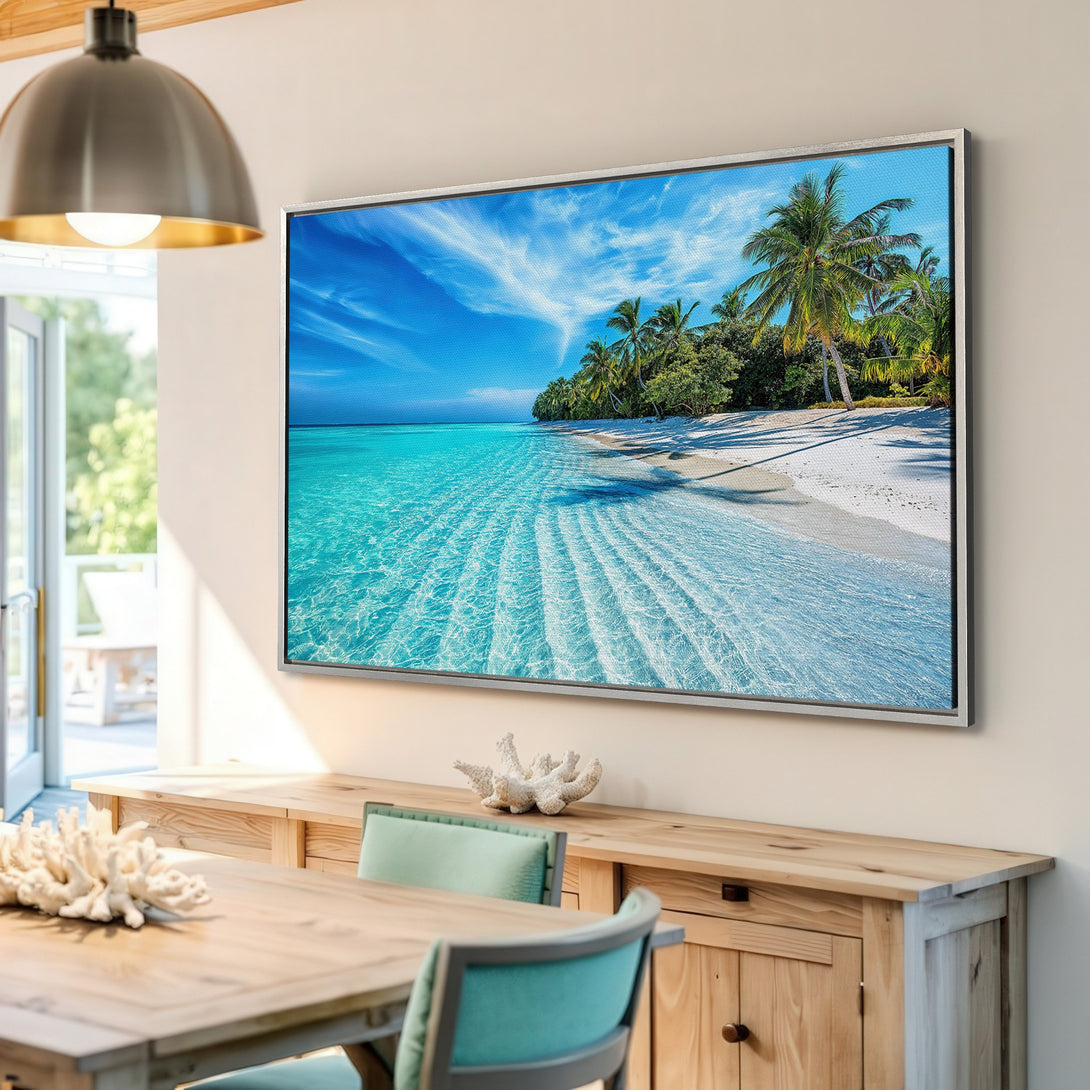 Framed Wall Art: Tropical beach scene Canvas Print with turquoise water, white sand, and palm trees. Coastal decor in a bright, airy interior.