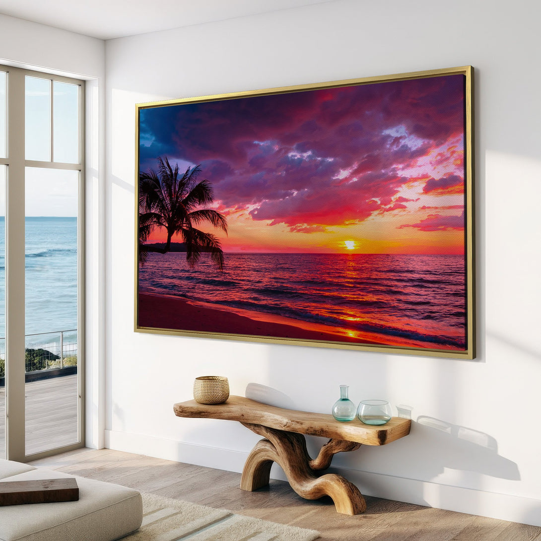 Canvas Print of a vibrant sunset over the ocean, featuring a palm tree silhouette. Warm red, orange, and purple hues create a stunning tropical scene.